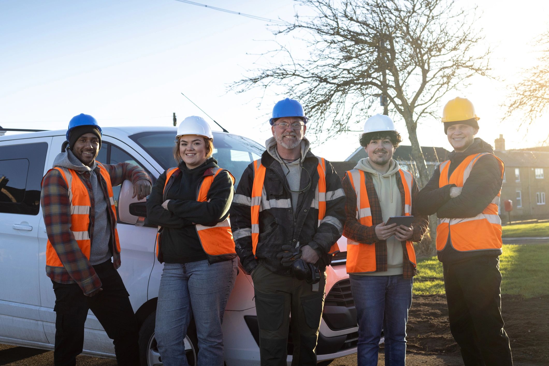 Family-oriented maintenance crew standing together at a property worksite